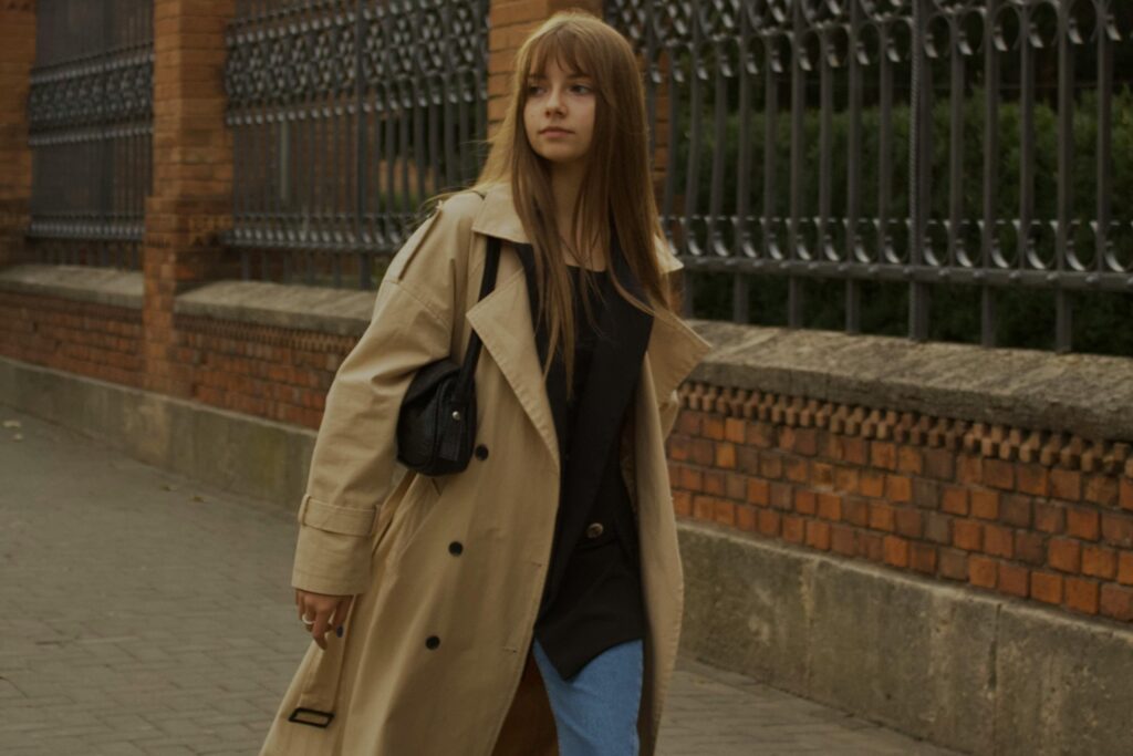 Image of an elegant woman wearing trench coat and light jeans